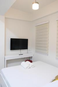 利帕LuxeCara Guest House的白色的客房配有两张床和电视。