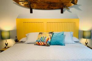 沃尔卡诺Puolani Iki-Sweet lil cottage near National Park的一张带两个枕头的床和两盏灯