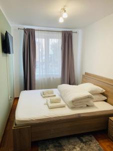 上维谢乌David Residence的一间卧室配有一张带白色床单的床和一扇窗户。