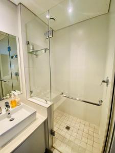 乌姆兰加Dolce vita luxurious apartment的带淋浴和盥洗盆的白色浴室