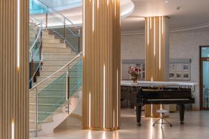 金沙MiRaBelle Hotel - Half Board Plus & All Inclusive的大堂设有钢琴和楼梯