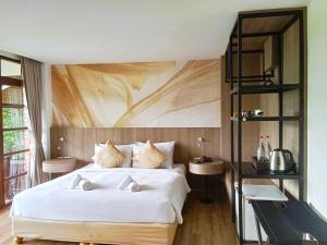 穆克莱克查尔伊萨拉酒庄度假村的卧室配有一张白色大床和木墙