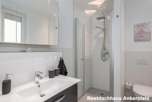 佩佩洛Reetidyll am Haff的白色的浴室设有水槽和淋浴。