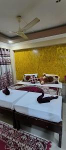 帕罗林ALEGRO HOLIDAY HOMES的一间卧室设有两张床和黄色的墙壁