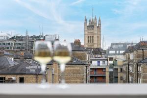 伦敦JOIVY Luxury flats near Big Ben and London Eye的享有城市美景,提供两杯葡萄酒