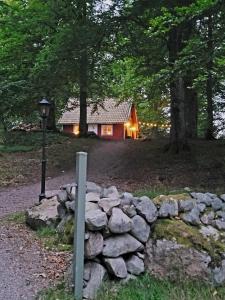 Skånes FagerhultBlueberry Hill的木头上的小木屋,设有石墙