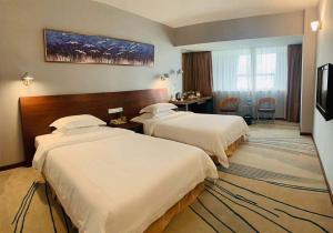 广州广州戴斯酒店的酒店客房配有两张床和一张书桌