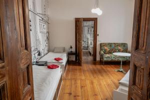 莱什诺Atelier Hostel的配有床、椅子和桌子的房间