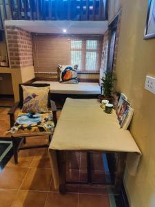 坎哈Surwahi Social Ecoestate Kanha的客房设有两张桌子、一张沙发和一个窗口