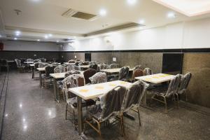 新德里Hotel Kabir Palace Karol Bagh的空的饭厅,配有桌椅