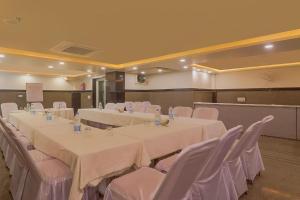 新德里Hotel Kabir Palace Karol Bagh的一间会议室,配有白色的桌子和白色的椅子
