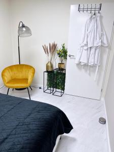 蒂尔WellnessStudioTiel的一间卧室配有黑色的床和黄色的椅子