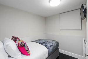 伦敦Unique single occupancy studio的卧室配有带枕头的白色床