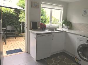布里斯班Jacaranda House Garden Suite的厨房配有水槽和洗衣机
