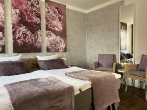 巴特皮尔蒙特Rein Klassik Hotel的一间卧室配有两张床和两把椅子