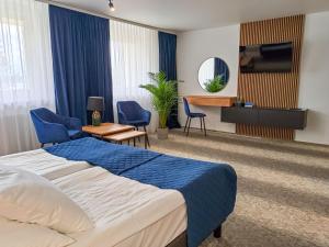 斯马德泽维采克弗兰诺热克雷西莫洛中央酒店的酒店客房配有床、椅子和电视。