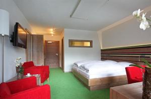 拉尔埃德尔餐厅-酒店的酒店客房,配有床铺和红色椅子