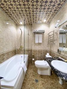 撒马尔罕GRAND HOTEL SOGDIANA的带浴缸、卫生间和盥洗盆的浴室