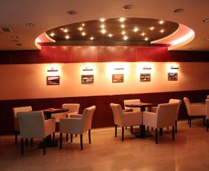 乌日霍罗德普拉哈酒店的用餐室配有桌椅和灯光