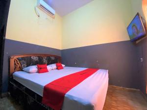 PalopoRedDoorz @ Wisma Sentosa Palopo的一间卧室配有一张带红色枕头的床