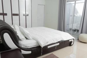 HithadhooMiyaheli Inn的一张带白色床单和枕头的床