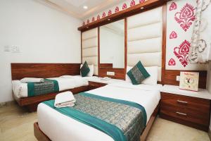 新德里Hotel Kabir Palace Karol Bagh的一间卧室配有两张床和镜子