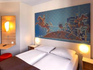 马格德堡B&B HOTEL Magdeburg-City的一间卧室配有一张壁画床