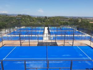 卡斯特尔德费尔斯CoolTainer retreat: Sustainable Coastal forest Tiny house near Barcelona的网球场上的一排蓝色网球场