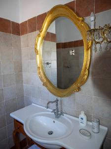 阿波罗尼亚Anemoessa Studios的浴室设有白色水槽和金色镜子