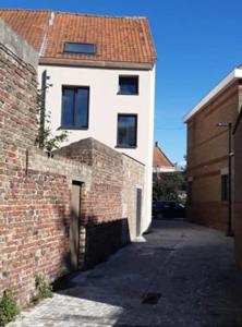 迪克斯梅德Kleine Dijk的砖砌建筑旁的白色建筑,有红色屋顶