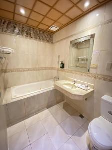 高雄艾萊商務汽車旅館的一间带水槽、浴缸和卫生间的浴室