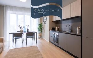 米兰Daplace - Portaluppi Apartment的一间带桌子的厨房和一间带厨房的用餐室