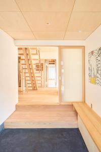 OchiCarpe Diem Kamaida的客房铺有木地板,设有楼梯。