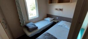 卡斯特拉讷Camping Les Sirènes的小型客房 - 带2张床和窗户