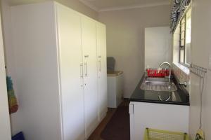 马盖特Seagull Road 838的厨房配有白色橱柜和水槽