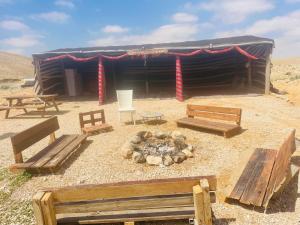 米茨佩·拉蒙חאן נחל חווה Han Nahal Hava的沙漠中一座带长椅和火的小屋