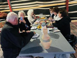 米茨佩·拉蒙חאן נחל חווה Han Nahal Hava的一群人坐在桌子旁,带花瓶