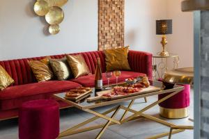 StaffelfeldenGîte au coeur de l'Alsace Maison Gatsby的客厅配有红色的沙发和带食物的桌子