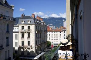 格勒诺布尔Le Grand Hôtel Grenoble, BW Premier Collection by Best Western的站在城市的阳台上的女人
