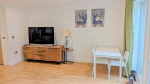 伦敦3 Bedroom house in Camberwell的客厅配有电视、书桌和桌子。