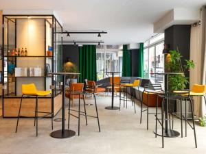 波城Ibis Pau Centre的一间酒吧,房间内设有黄色的椅子和桌子