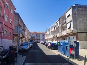 阿马多拉Lisbon traditional T2 with balcony in Damaia, Lisbon的一条城市街道,有停车的汽车和建筑