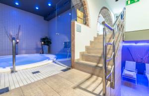 安道尔城Hotel Spa Termes Carlemany的带浴缸、楼梯和楼梯的浴室