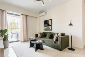 雅典Radiant 2BR Apartment in Neo Psichiko by UPSTREET的客厅配有绿色沙发和桌子