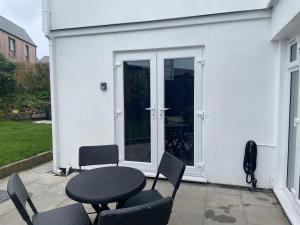 卡比斯贝Carbis Bay Suite, Carbis Bay, St Ives, free parking, near beach的大楼前带桌椅的天井