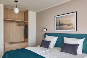 汉堡Makro Apartments的一间卧室配有一张蓝色床头板的床
