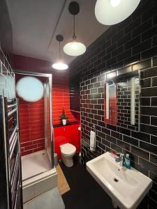 伦敦Glasshouse yard studio's F1的一间带水槽和卫生间的浴室以及红色的墙壁。
