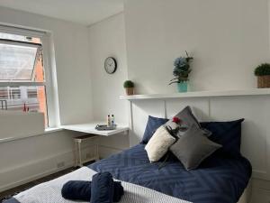 伦敦Glasshouse yard studio's F1的一间卧室设有蓝色的床和窗户。