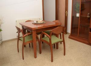 特拉萨Apartamentos Atlas Terrassa IV (Les Escoles)的一张带椅子的木桌和一盘食物