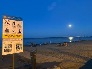 圣地亚哥德拉里贝拉Hotel Ribera的海滩上与海滩上的人的标志